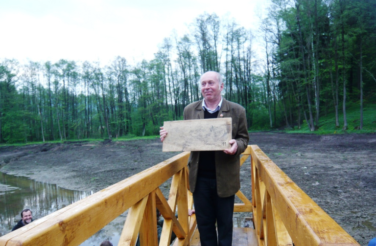 Starosta Osečné Jiří Hauzer spustil včera stavítka do požeráku Jenišovského rybníku.